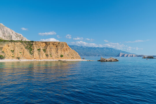 Serene coastal landscape with rocky cliffs and clear blue water - Powered by Adobe