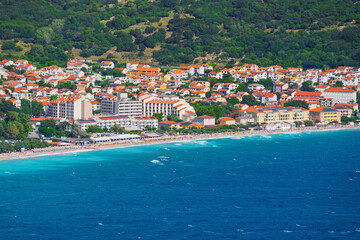 Fototapeta premium Coastal townscape with mountain background and vibrant blue sea. Baška, Krk island, Croatia