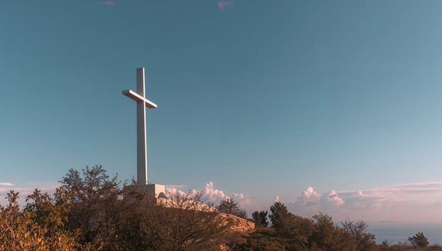 Large white cross monument on Marjan hill under a blue sky, preservation