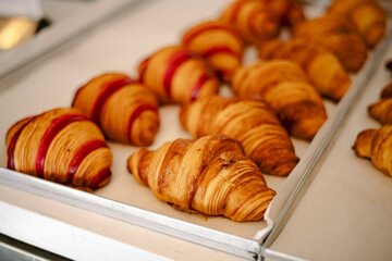 Appetizing freshly baked berry raspberry croissants in the bakery window.