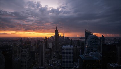 Fototapeta premium Tall buildings silhouetted against early morning sky ahead of approaching storm