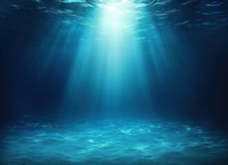 Sunlight rays penetrating clear blue ocean water illuminating sandy sea floor, creating a serene and tranquil underwater scene