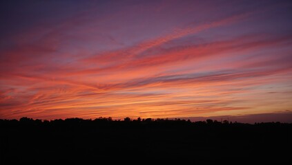 Fototapeta premium Silhouette of a village against a beautiful sunset sky, rural tranquility