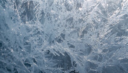 Fototapeta premium Ice crystals forming on a window surface, showcasing winter's intricate patterns
