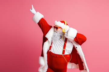 Santa dancing in a bright pink studio wearing red suit and fluffy trim headphones playful pose for holiday magic and festive family celebration