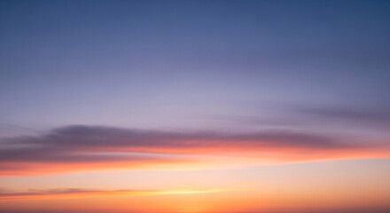 Obraz premium Vibrant Sunset Sky with Wispy Clouds and Gradient Colors Over Horizon