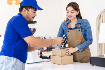 Fototapeta premium Deliveryman confirming parcel with cafe owner woman using smartphone, representing digital signature, cashless payment, efficient collaboration between delivery service and small business logistics