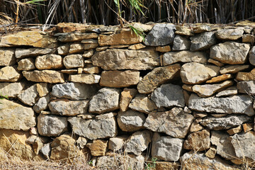Natural stone wall as a fence in a field