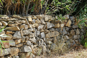 Natural stone wall as a fence in a field