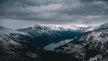 Aerial view of a snow-capped mountain range under a cloudy sky, erosion risk