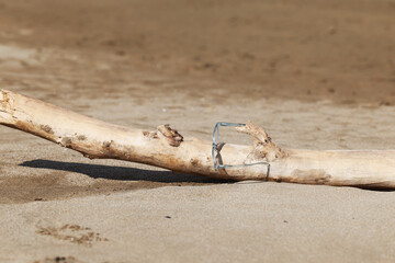 Glasses on the beach on a piece of wood 