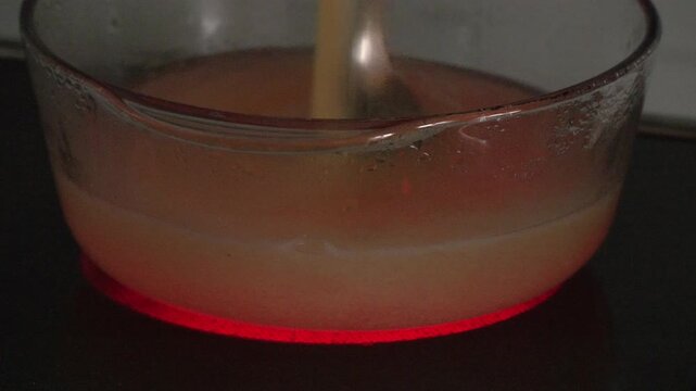 4K UHD close up footage of cooking polenta in transparent glass pot