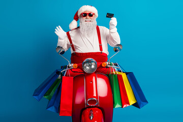 Santa on a red scooter with colorful shopping bags smiles as he holds a card against a bright blue background
