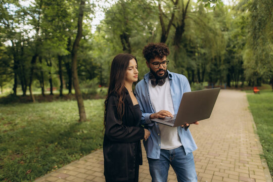 Diverse colleagues working outdoors on a laptop
