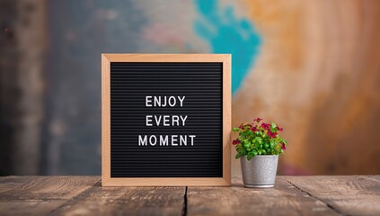 Letter board with Enjoy Every Moment phrase, functional decor for mindfulness