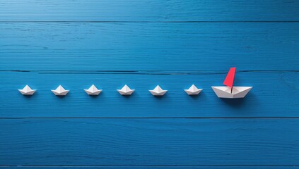 Leadership theme with paper boats on blue wood surface, teamwork dynamics