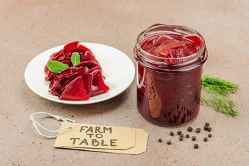 Fermented beetroot slices in a glass jar and on a plate. Homemade food, probiotic-rich, vegan