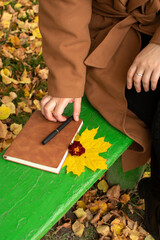 Woman puts pen on brown cover notebook