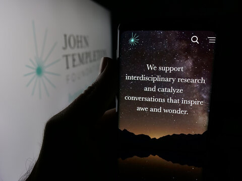 Stuttgart, Germany - 10-31-2025: Person holding smartphone with web page of US organisation John Templeton Foundation on screen in front of logo. Focus on center of phone display.
