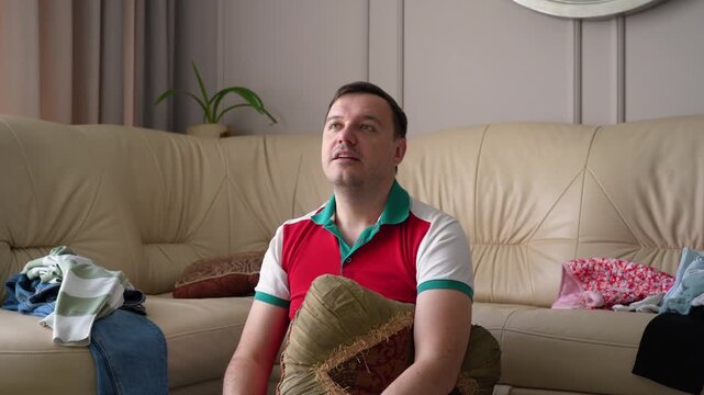 Man on sofa shifts from thoughtful reflection to ecstatic celebration and back to contemplation.