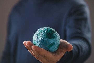 Environmental sustainability and global responsibility concept with human hand holding paper earth model, symbolizing eco awareness, planet protection, environmental conservation for a greener future.