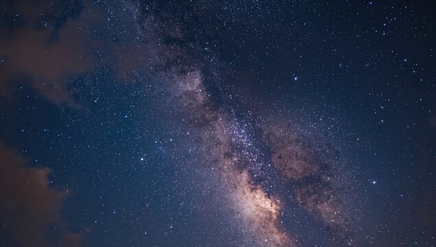 A clear night sky filled with stars and clouds, showcasing seasonal change