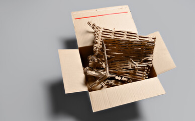 Opened cardboard box displaying dense riffled corrugated cardboard filler material with bubble wrap...