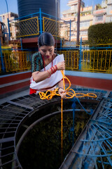 Newari Girl in tradional attire Drawing Water from a Traditional Hiti