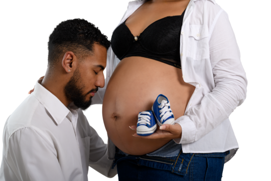 expectant parents with baby shoes