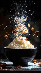 Dynamic high-speed shot of crushed cookies and nuts splatte into a black bowl with powdered sugar and falling ingredients on dark background