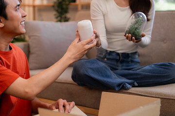 Asian couple home decoration unpacking moving new living space happy domestic life sharing items cozy apartment interior design together adult lifestyle