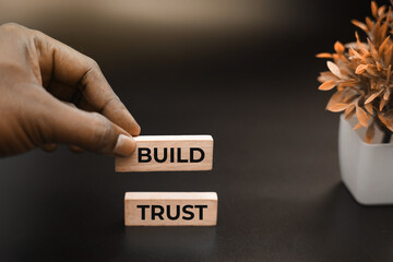 Build trust message displayed on wooden blocks, symbolizing teamwork, leadership, and business success.