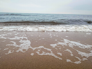 Sea waves rolling on sandy beach shore