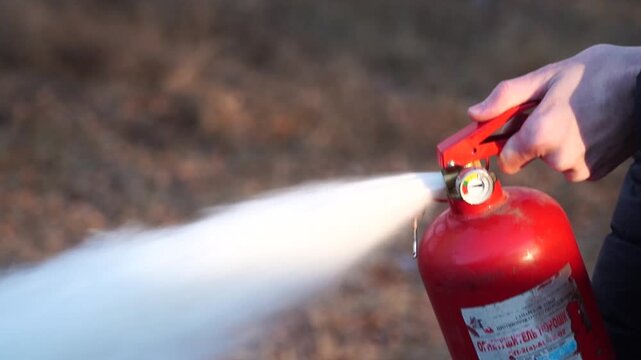 Man using fire extinguisher in a fire.