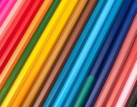 Close-up angled view of a row of aligned colorful pencils