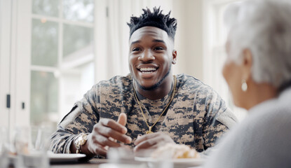 Young african american soldier smiling at elderly woman in cozy home setting