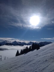 Skiing in snow-covered mountains in the Alps with beautiful sun 