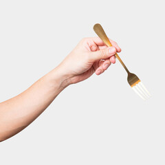 isolated of a man's hand holding a golden steel fork.