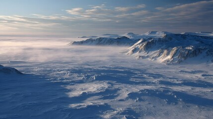 A vast snow covered mountainous landscape shrouded in mist under a soft cloudy sky