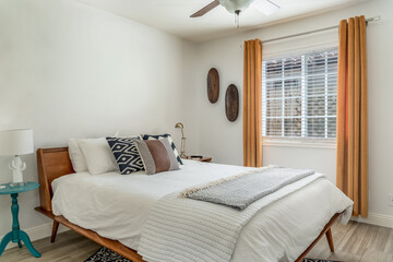 Modern desert bedroom interior with wood frame bed accent pillows