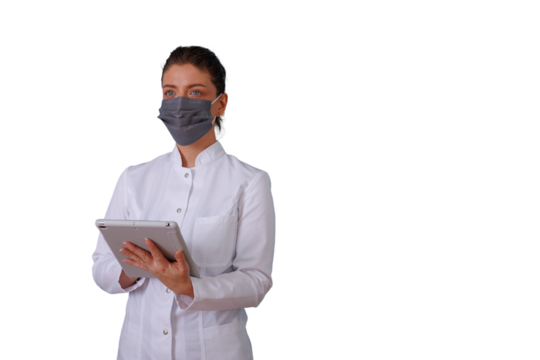 Female medical professional wearing a face mask and white coat, holding a digital tablet, working in healthcare, transparent background
