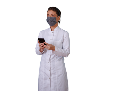 Female medical professional wearing face mask and white lab coat, using smartphone for communication, transparent background