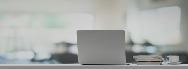 Front view laptop on white table In office workplace. 3D rendering
