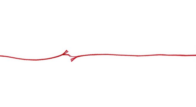 A single red string is broken on a clean white background telling a symbolic story of separation