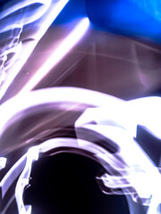 Colorful, fluorescent swirls of light create a dynamic and energetic abstract composition. Blurred streaks of purple, blue, and gold give the impression of rapid, surreal movement.