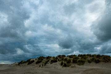 dark clouds cast shadows on silent sands, tense scene of storm approaching over empty shores