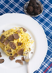 Black truffle and fresh pasta Tajarin. Magical autumn light. Autumn gourmet cuisine of Piedmont, Northern Italy, Spain and France