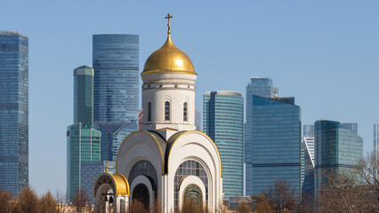 View of the church and skyscrapers. Modern city landscape. A beautiful church against the backdrop of high-rise buildings. Traditional and modern architecture in the metropolis. Moscow, Russia.