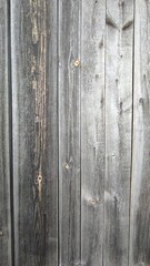 Naklejka premium Weathered Wooden Fence With Gray Planks Showcasing Natural Textures and Patterns in Outdoor Setting
