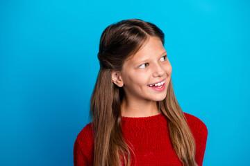 Fototapeta premium Smiling girl in red sweater against blue background captures festive winter mood and joy